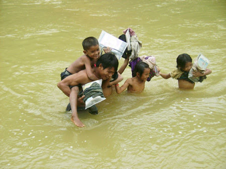 Thầy giáo cõng học sinh qua suối đến trường